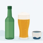 緑色の焼酎瓶とビールグラス、並んで置かれた韓国の酒とその器